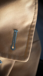 Blue,thread,stitch,button,hole,in,trench,coat
